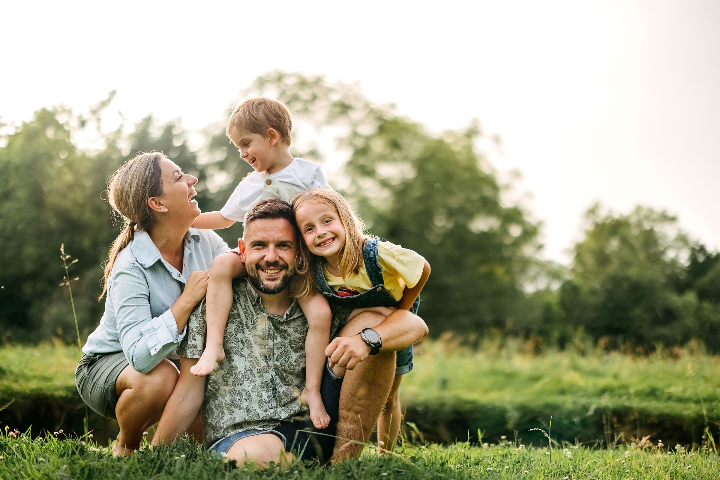 Family poses for a photo on a grass field.