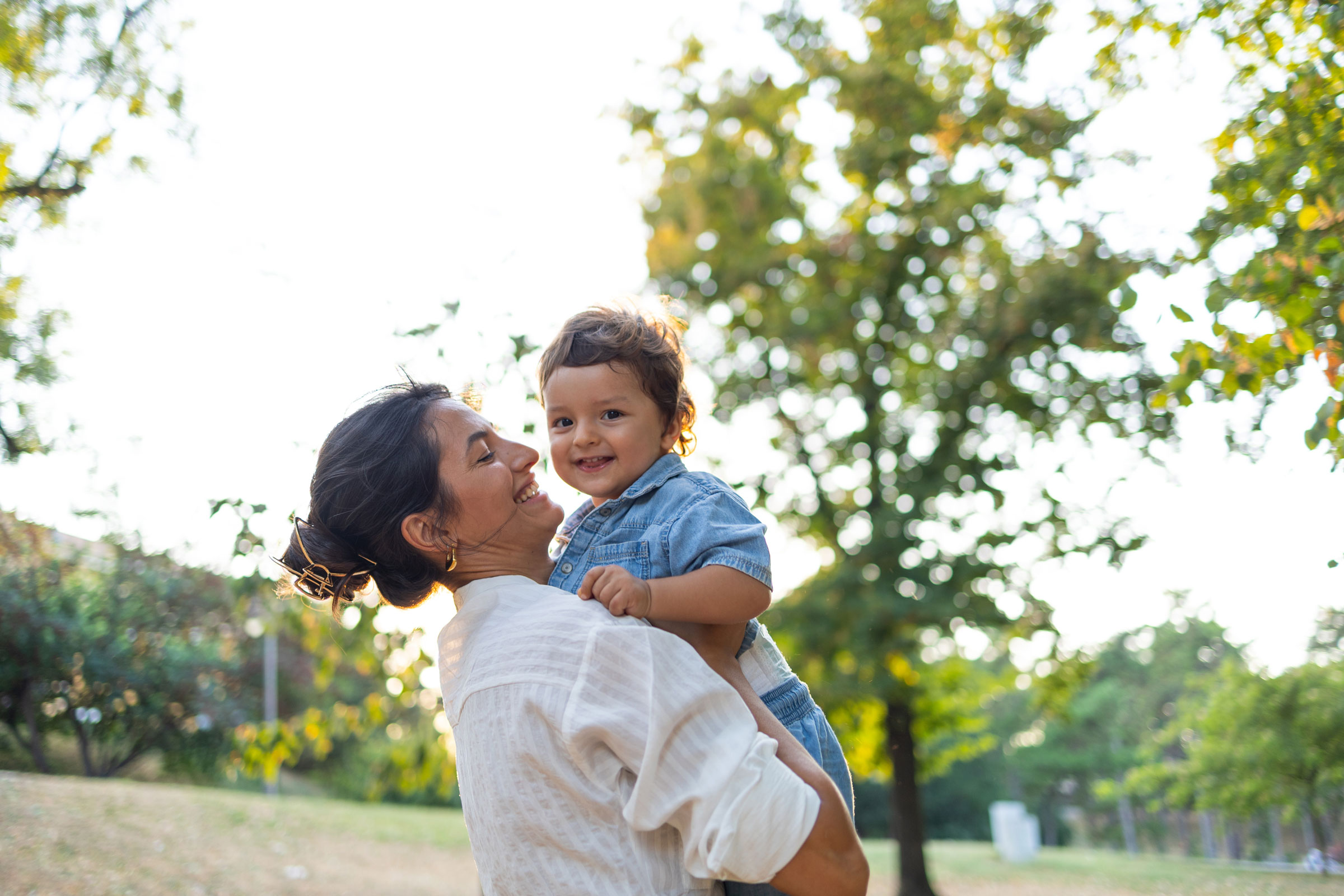 A woman holds a young child.